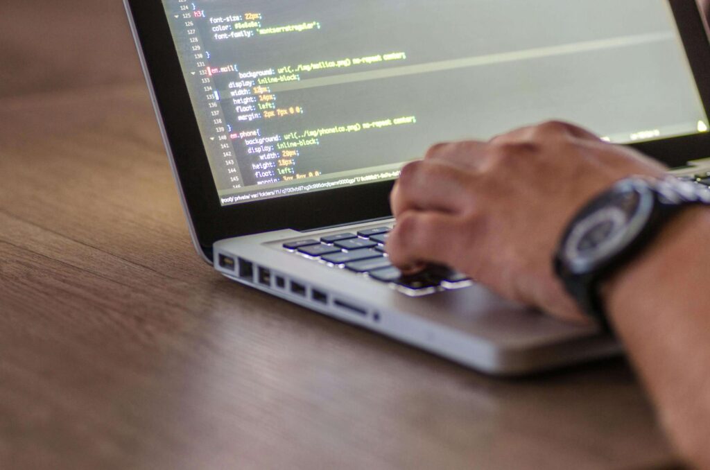person coding on laptop
